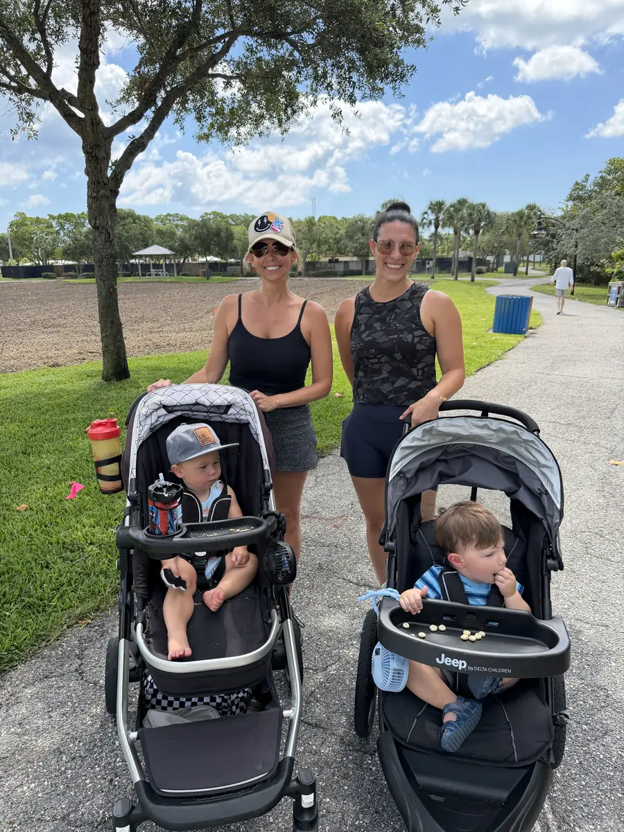 Two moms with strollers on a park path